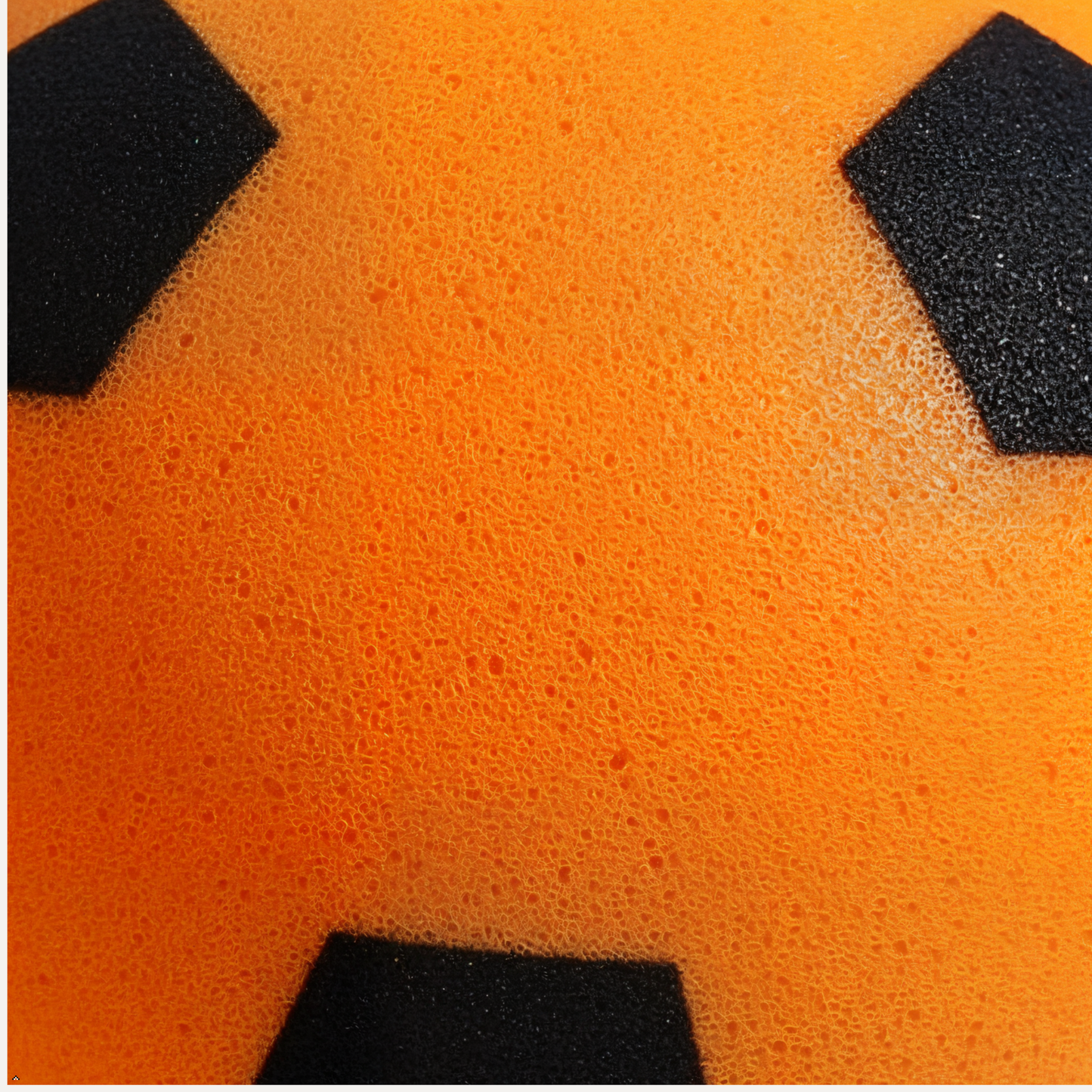 Close-up of an orange foam ball with black patches