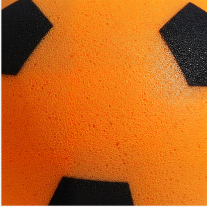 Close-up of an orange foam ball with black patches